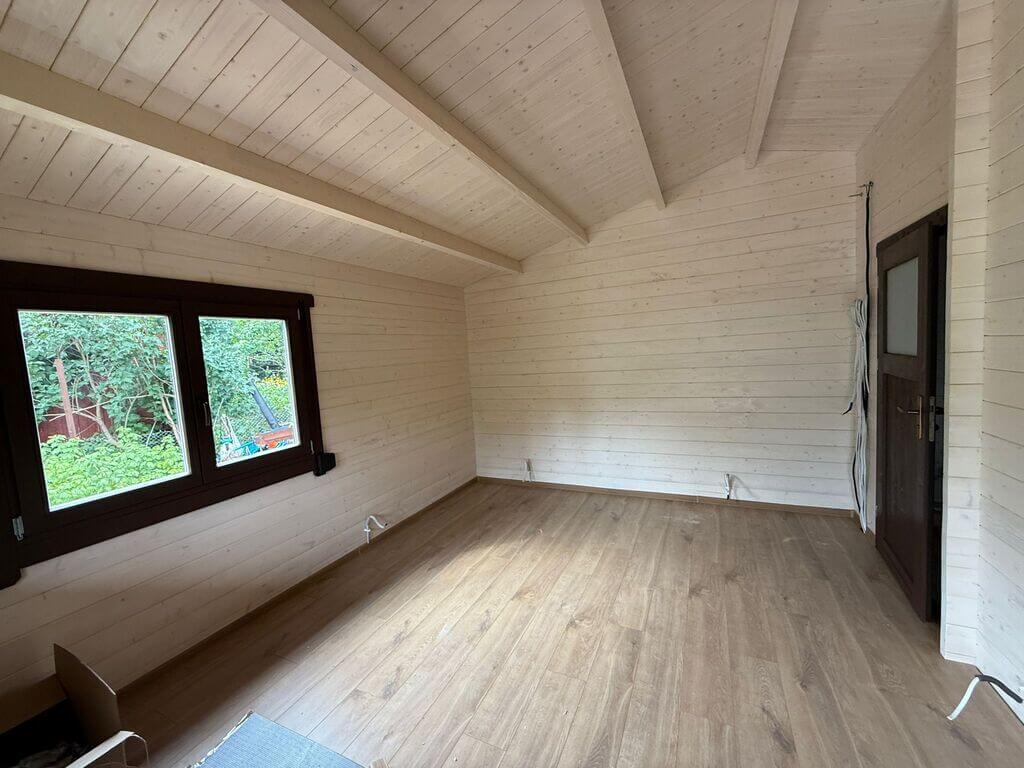 Wnętrze drewnianego domu z panoramicznymi oknami.