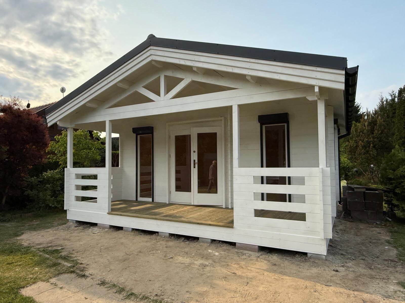 Biały, drewniany dom na terenie zewnętrznym.