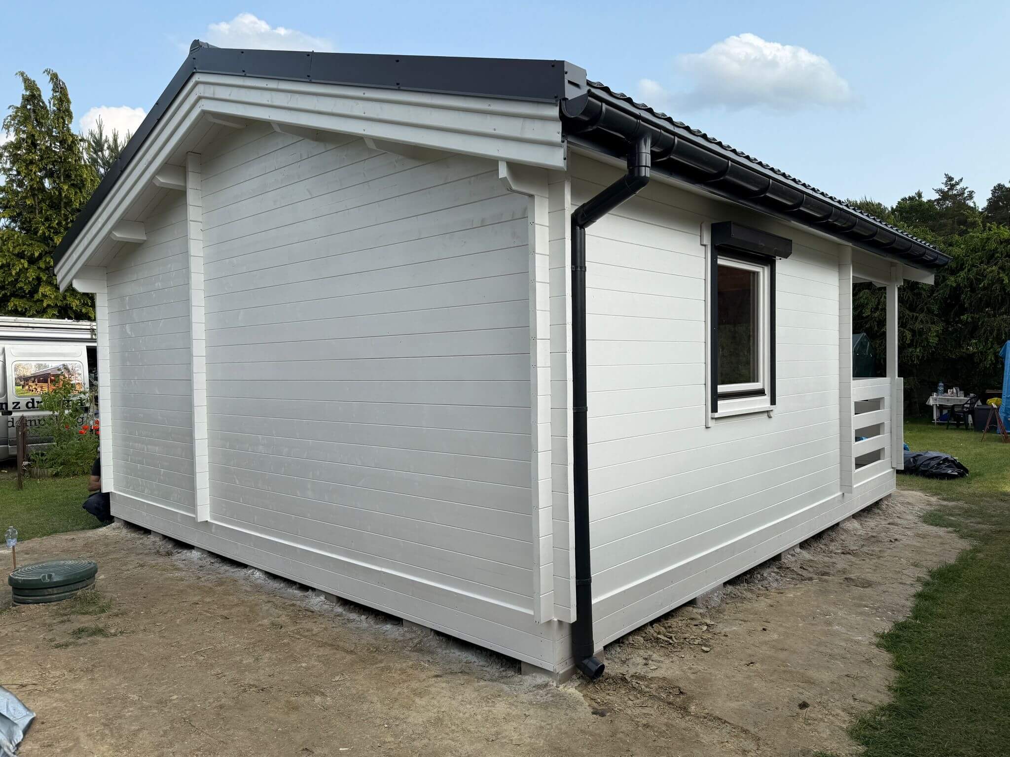 Mały, biały dom na podwórku.