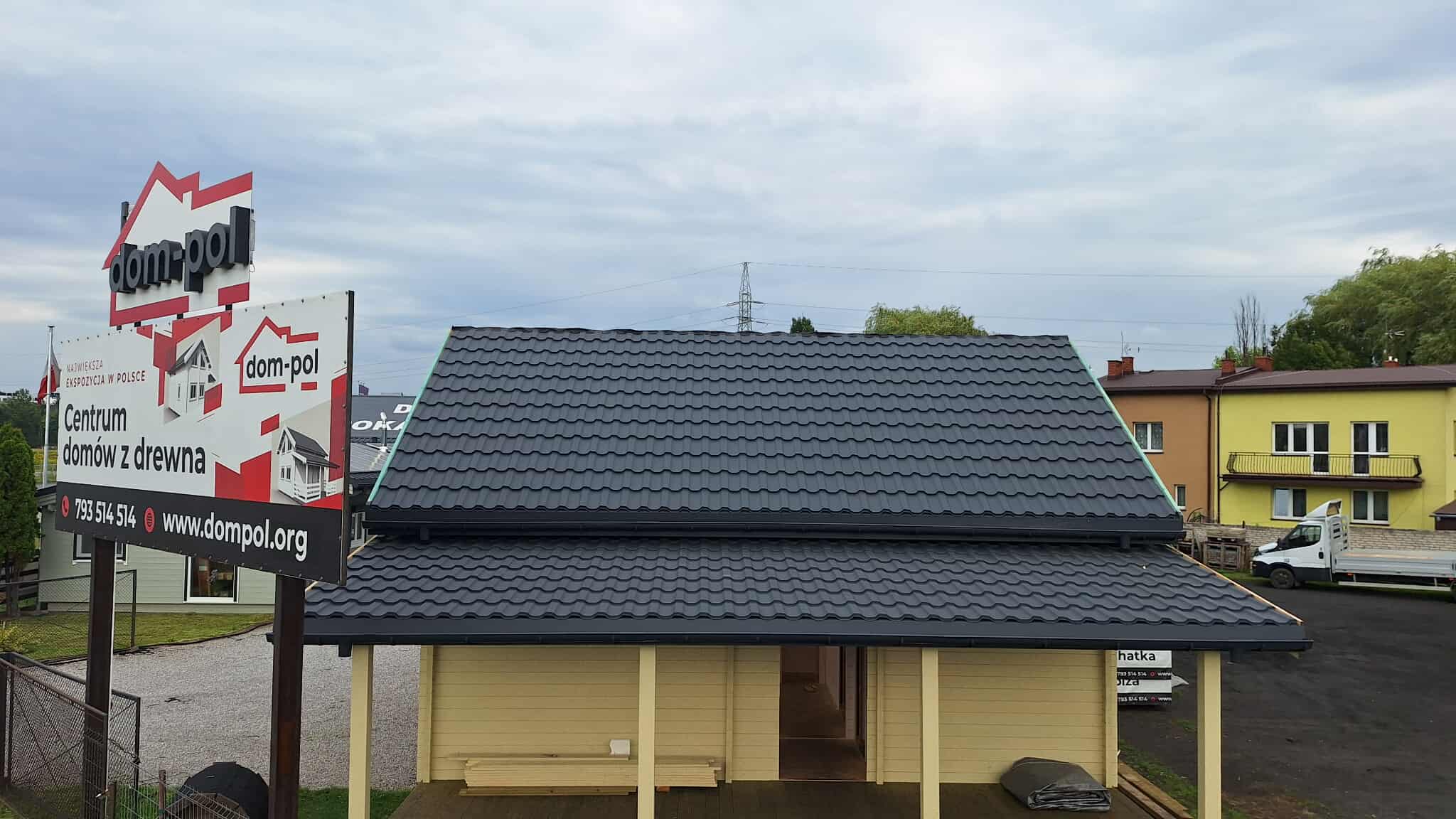 Dach domu przykryty antracytową blachodachówką.