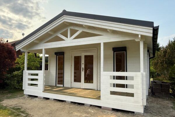 Biały drewniany dom z tarasem.