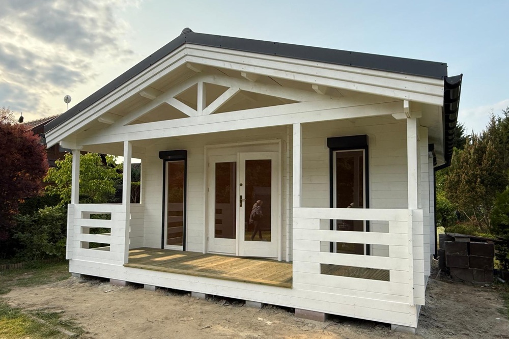 Biały drewniany dom z tarasem.